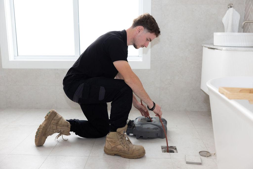 GSK Plumbing Solutions plumber clearing a blocked drain in Sydney