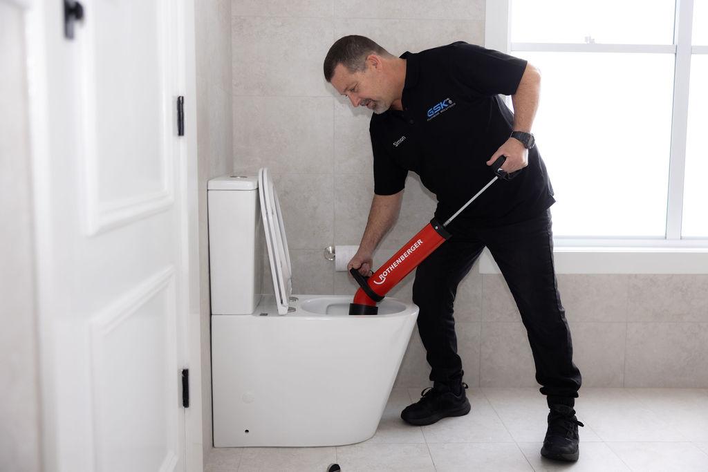 GSK Plumbing Solutions plumber repairing a blocked toilet in Sydney